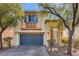 Two-story house with gray garage door and landscaped yard at 9802 Twin Mill St, Las Vegas, NV 89178