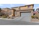 Two-story house with stone accents and a gray garage door at 10350 Blue Ginger Dr, Las Vegas, NV 89135