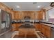 Modern kitchen with light wood cabinets, granite countertops, and stainless steel appliances at 10350 Blue Ginger Dr, Las Vegas, NV 89135