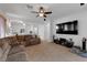 Open living area with a large TV, sectional sofa and ceiling fan at 10350 Blue Ginger Dr, Las Vegas, NV 89135