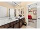 Double vanity bathroom with view into adjacent bedroom at 10825 Bernini Dr, Las Vegas, NV 89141