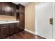 Laundry room with dark wood cabinets and built-in sink at 10825 Bernini Dr, Las Vegas, NV 89141