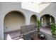 Virtually staged courtyard with arched entryway and seating area at 12237 Olivetta Ct, Las Vegas, NV 89138