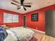 Red-walled bedroom with a bed, hardwood floors, and a window with shades at 1760 Westwind Rd, Las Vegas, NV 89146