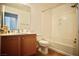 Bright bathroom features a tub/shower combo and vanity with wooden cabinets at 23 E Agate Ave # 506, Las Vegas, NV 89123