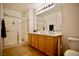 Bathroom with a double sink vanity, large mirror, and a tiled shower with glass door at 23 E Agate Ave # 506, Las Vegas, NV 89123