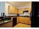 Bright kitchen featuring wooden cabinets, granite countertops, and black appliances at 23 E Agate Ave # 506, Las Vegas, NV 89123