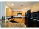 The well-lit kitchen features modern black appliances and granite counters at 23 E Agate Ave # 506, Las Vegas, NV 89123