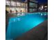 Large, inviting outdoor pool area with umbrella-covered lounge seating and building amenities at nighttime at 23 E Agate Ave # 506, Las Vegas, NV 89123
