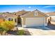 Tan house with a two-car garage and desert landscaping at 2755 Sunken Ship St, Laughlin, NV 89029