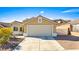 Tan one-story house with a two-car garage and desert landscaping at 2755 Sunken Ship St, Laughlin, NV 89029