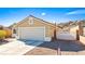 Tan house with a two-car garage and desert landscaping at 2755 Sunken Ship St, Laughlin, NV 89029