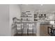 Stylish bar area with granite countertop and seating, complemented by floating shelves and modern decor at 30 Hilltop Crest St, Henderson, NV 89011