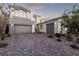 Exterior of home with multi-car garage, desert landscaping and paver driveway at 30 Hilltop Crest St, Henderson, NV 89011