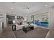 Open-concept living room featuring a comfortable sofa, modern decor, and seamless access to the outdoor pool at 30 Hilltop Crest St, Henderson, NV 89011