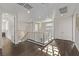 Modern upper hallway with dark hardwood floors, metal railing, and access to multiple rooms at 30 Hilltop Crest St, Henderson, NV 89011