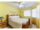 Bright bedroom with wooden bed frame, ceiling fan and yellow walls at 349 Yacht Ave, Henderson, NV 89012