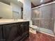 Bathroom with dark vanity, tile shower, and marble floor at 3597 Arville St # 203B, Las Vegas, NV 89103