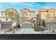 Three-story townhouses with attached garages and landscaping at 368 Gracious Way, Henderson, NV 89011