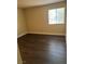 Bright bedroom with dark brown wood-look flooring and large window at 4965 Indian River Dr # 103, Las Vegas, NV 89103