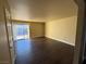 Living room with dark laminate floors and sliding glass doors to balcony at 4965 Indian River Dr # 103, Las Vegas, NV 89103