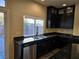 Modern kitchen features dark cabinetry, granite counters, and stainless steel appliances at 6538 Creekside Cellars Ct, Las Vegas, NV 89139