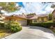 Inviting single-story home featuring a tile roof, attached garage, and lush green shrubbery at 7909 Rio Rico Dr, Las Vegas, NV 89113