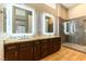 Main bathroom featuring double sinks, granite countertops, custom mirrors, and a glass walk-in shower at 7909 Rio Rico Dr, Las Vegas, NV 89113