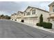 Exterior view of townhomes featuring multi-car garages and simple landscaping on a quiet street at 8834 Duncan Barrel Ave # 103, Las Vegas, NV 89178