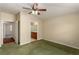 Bright bedroom with green carpet, ceiling fan, and access to hallway at 9389 Borough Park St, Las Vegas, NV 89178