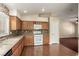 Kitchen with wood cabinets, tile backsplash, and white appliances at 9389 Borough Park St, Las Vegas, NV 89178