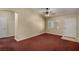 Living room with red carpet, ceiling fan, and neutral walls at 9389 Borough Park St, Las Vegas, NV 89178