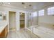 Main bathroom with soaking tub, shower, and walk-in closet at 10016 Diving Duck Ave, Las Vegas, NV 89117