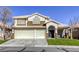 Two-story house with a three-car garage and landscaped lawn at 10016 Diving Duck Ave, Las Vegas, NV 89117