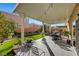 Covered patio with seating area and lush green lawn at 10166 Bishops Peak Ct, Las Vegas, NV 89141