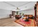 Light and airy living room with hardwood floors, leather furniture, and a large TV at 10166 Bishops Peak Ct, Las Vegas, NV 89141