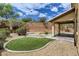 Landscaped backyard with putting green and patio at 10489 Bolting Cloud Dr, Las Vegas, NV 89178