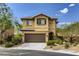 Two-story house with brown garage door and landscaping at 10489 Bolting Cloud Dr, Las Vegas, NV 89178