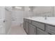 Modern bathroom with double vanity, bathtub, and gray cabinets at 11327 Gravitation Dr, Las Vegas, NV 89135