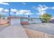 Ranch style home with gray exterior, white garage door, and landscaping at 1205 Sattes St, Las Vegas, NV 89101