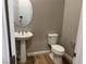 Clean bathroom with pedestal sink and toilet at 12422 Tudor Arch Dr, Las Vegas, NV 89138