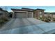 Two-story home with a three-car garage and paved driveway at 12422 Tudor Arch Dr, Las Vegas, NV 89138