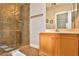 Bathroom with wood vanity, glass shower, and neutral tile at 167 White Butte St, Henderson, NV 89012