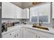 White kitchen with updated sink and faucet, and white cabinetry at 1992 Star Creek Bay Ln, Las Vegas, NV 89115