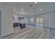 Open-concept living room with black kitchen island, modern lighting, and sliding glass doors at 380 Erin St, Pahrump, NV 89048