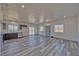 Open-concept living room with gray wood floors, recessed lighting, and sliding glass door to the backyard at 380 Erin St, Pahrump, NV 89048