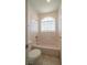 Clean bathroom with a bathtub, toilet and arched window at 4654 Stuttgart St, Las Vegas, NV 89147