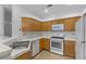 Kitchen features wood cabinets, white appliances, and tile countertops at 5155 W Tropicana Ave # 2123, Las Vegas, NV 89103