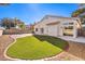 Landscaped backyard with artificial turf and brick patio at 5306 Falling Petals Dr, North Las Vegas, NV 89031