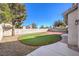 Landscaped backyard with artificial turf, block wall, and red brick patio at 5306 Falling Petals Dr, North Las Vegas, NV 89031